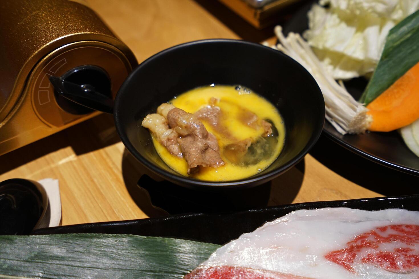 Close up Wagyu beef and pork, raw egg and dipping sauce- Sukiyaki Japanese hot pot photo