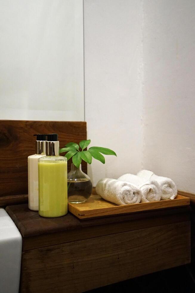 Rolled hand washing towels and cleaning gel bottles on wooden tray table photo