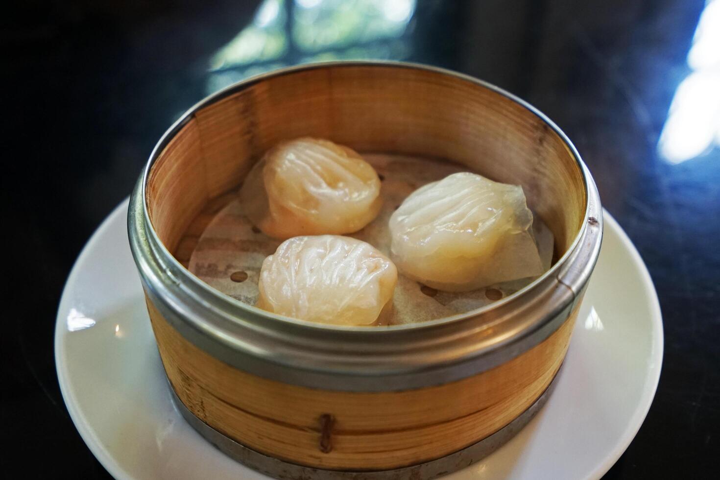 Close up Ha Gao Dim Sum, Chinese prawn dumplings served in steamed wooden basket container photo