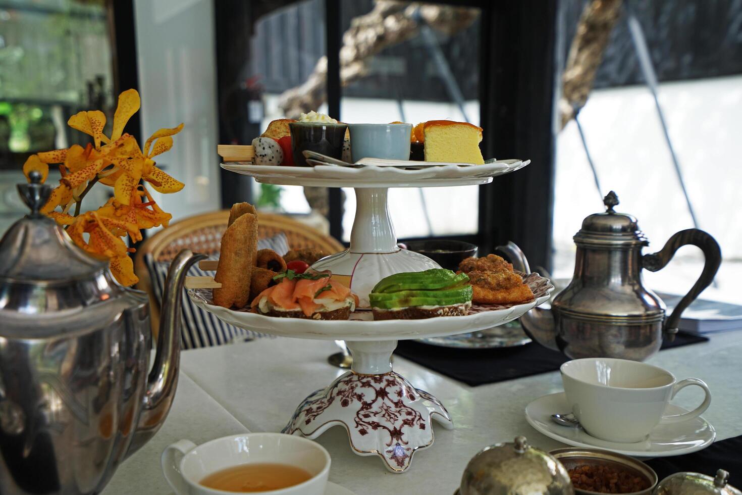 Afternoon tea served with bakery and pastry in Thai style smoked salmon and avocado toast photo
