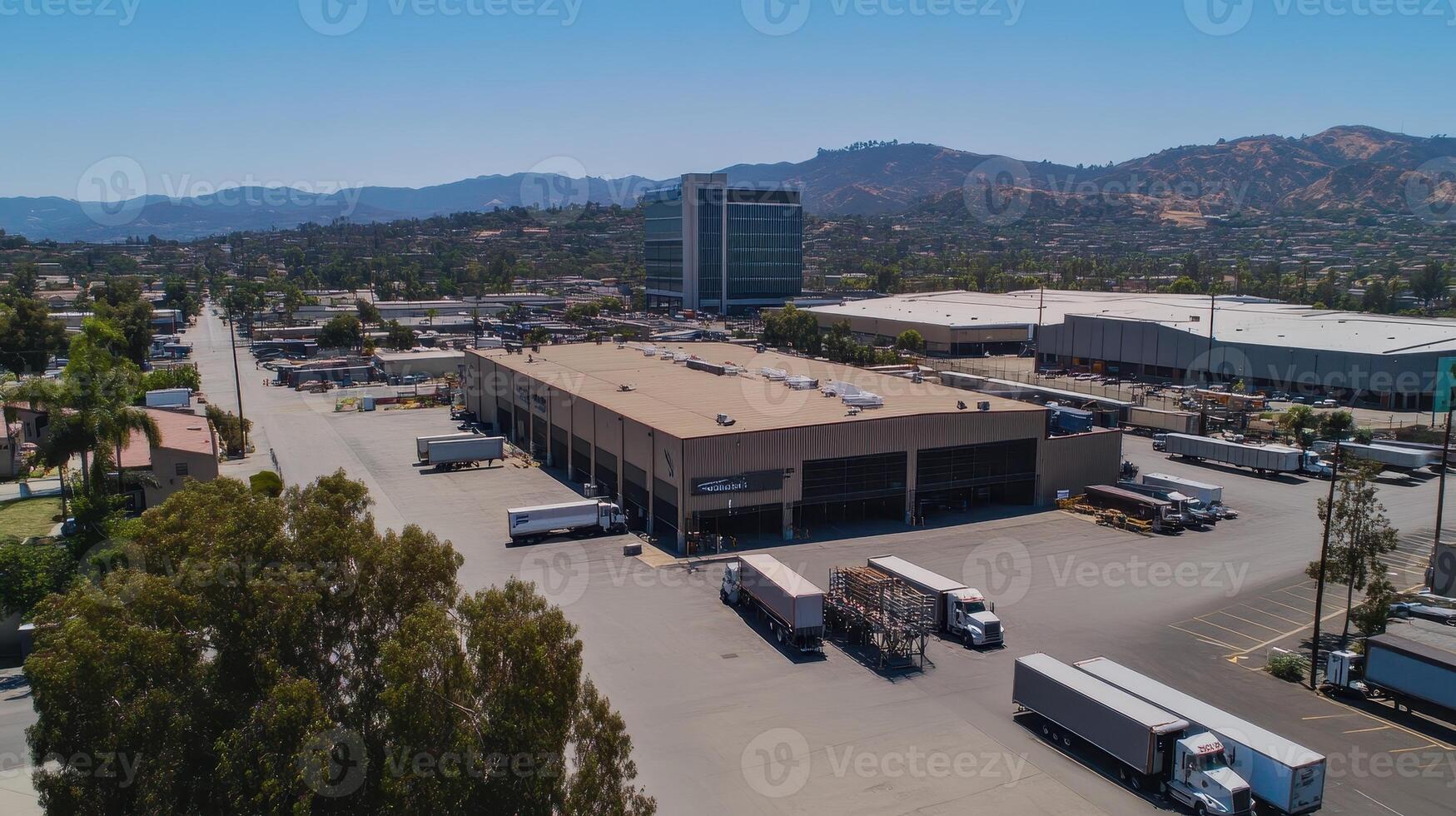Aerial view of a commercial area with trucks and buildings against a mountainous backdrop photo