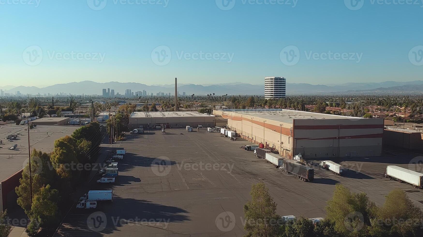 Aerial view of an industrial area with trucks and a city skyline in the background photo