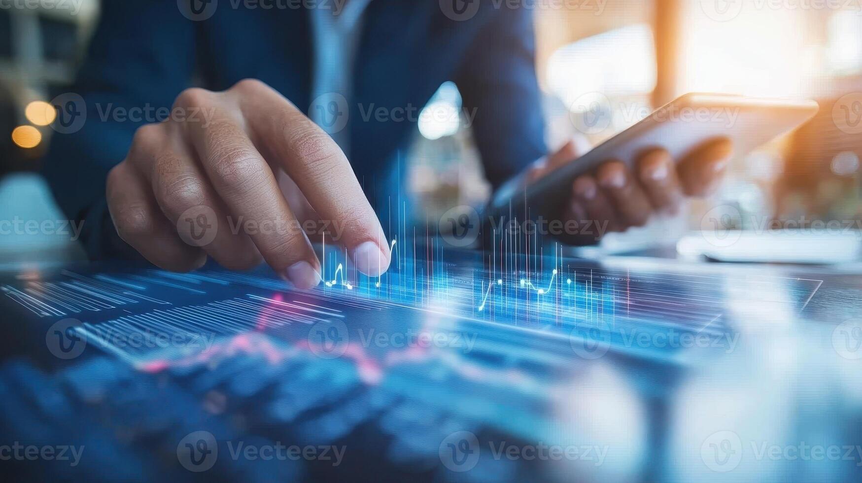 A person analyzing data on a smartphone with financial graphs displayed on a screen photo