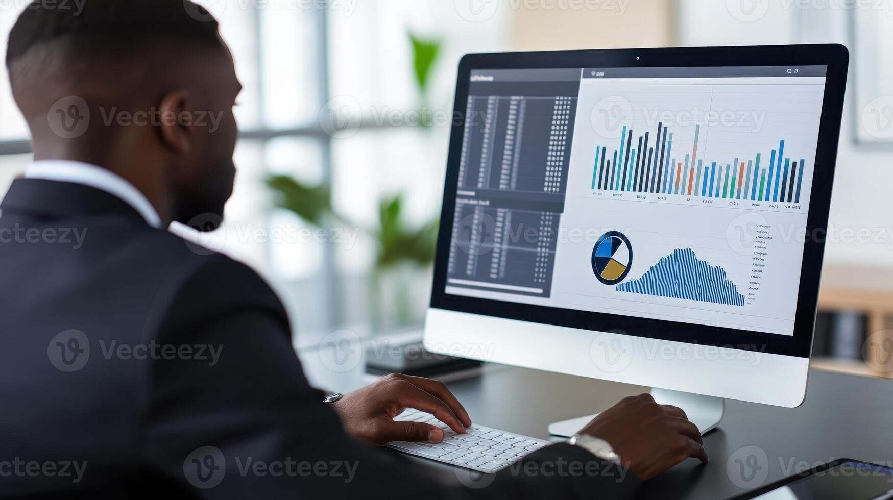 A professional analyzing data on a computer screen in an office setting photo