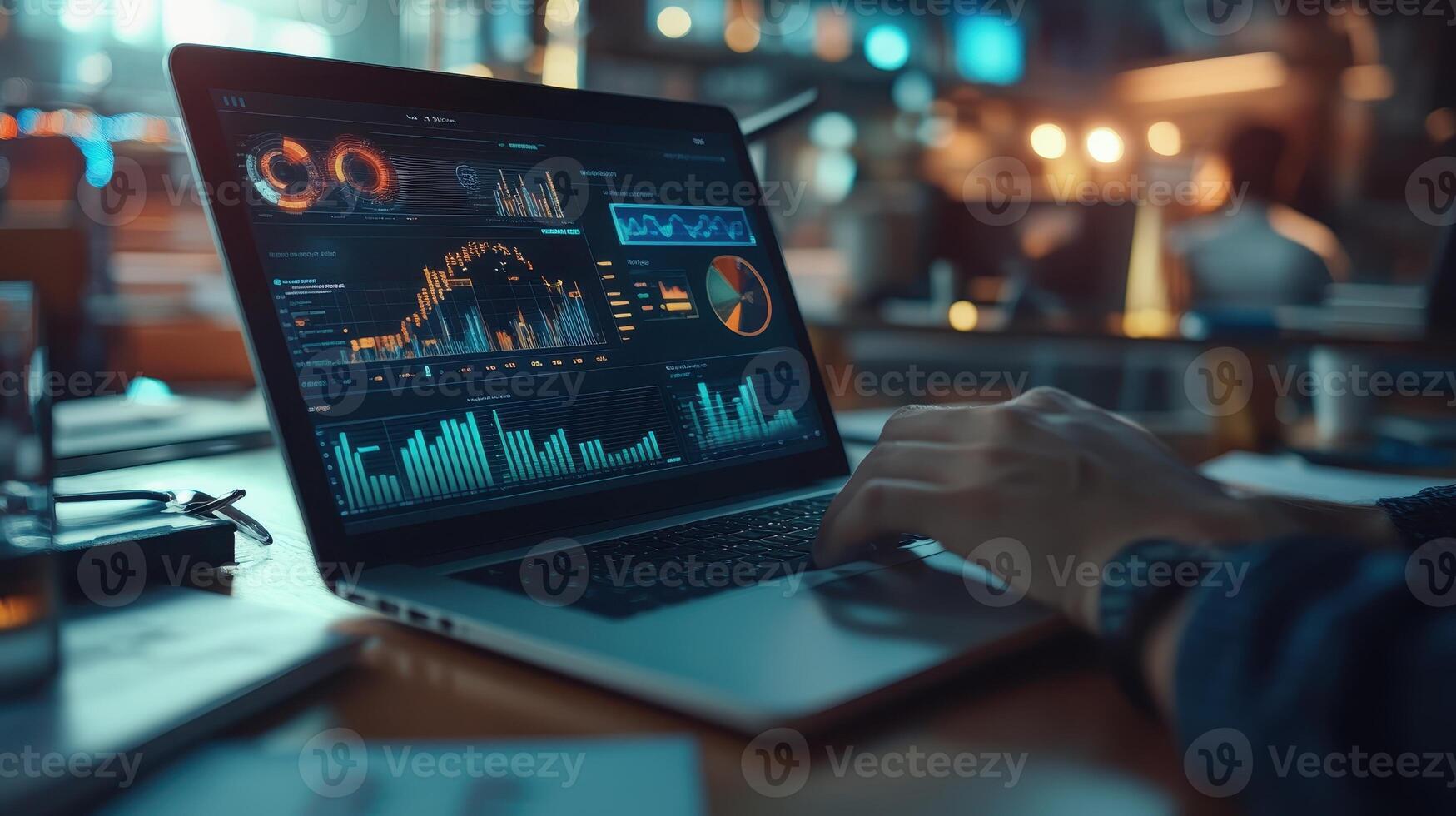 A person analyzing data on a laptop with various graphs and charts displayed photo