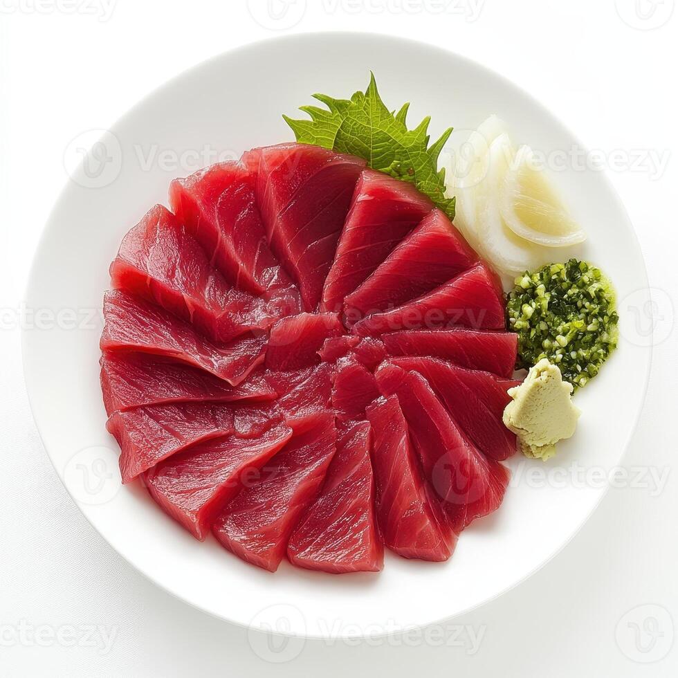 A plate of sashimi featuring thinly sliced tuna, garnished with wasabi and herbs. photo