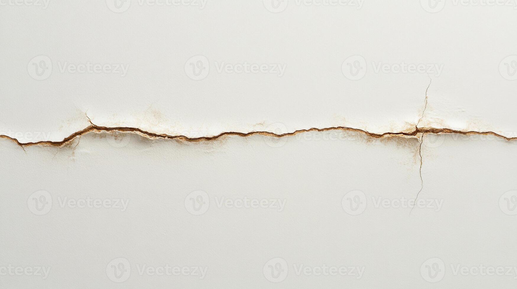 A close-up of a crack in a white wall, revealing underlying textures and colors photo