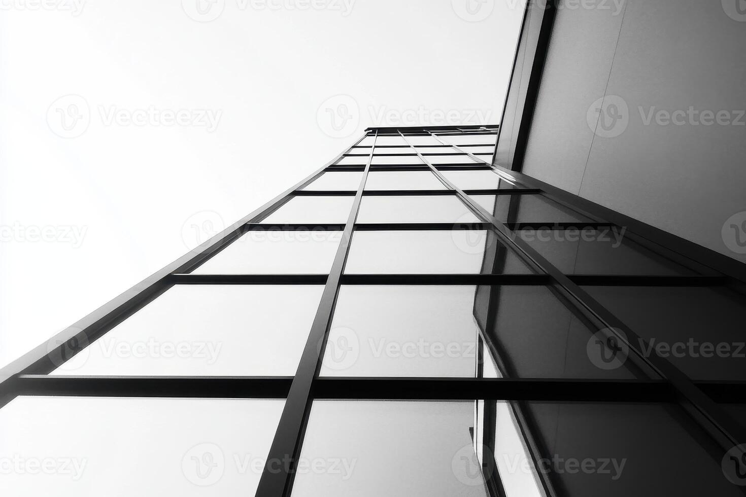 A low-angle view of a modern glass building, emphasizing its sleek architectural design. photo