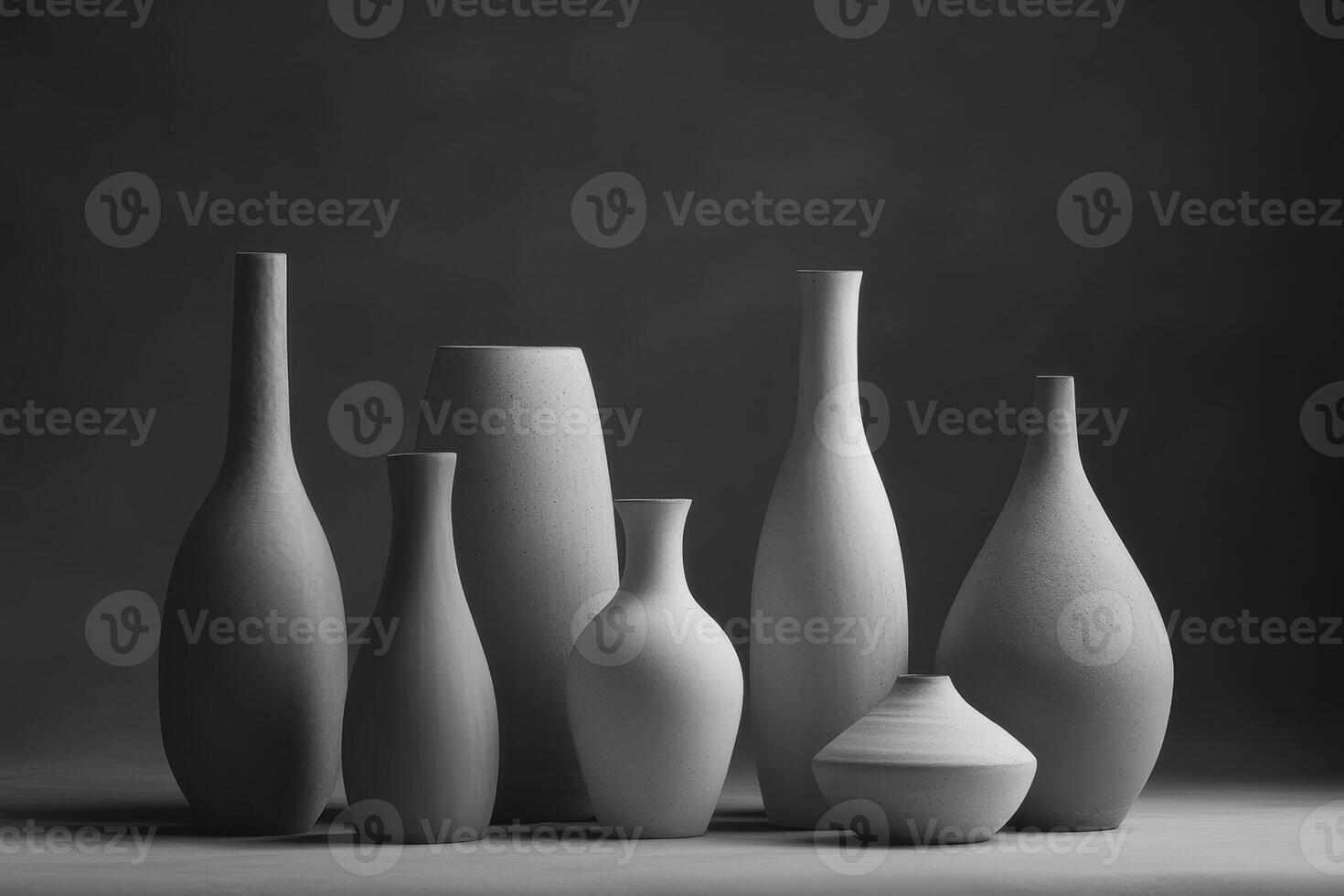 A collection of minimalist ceramic vases arranged artistically against a dark background photo