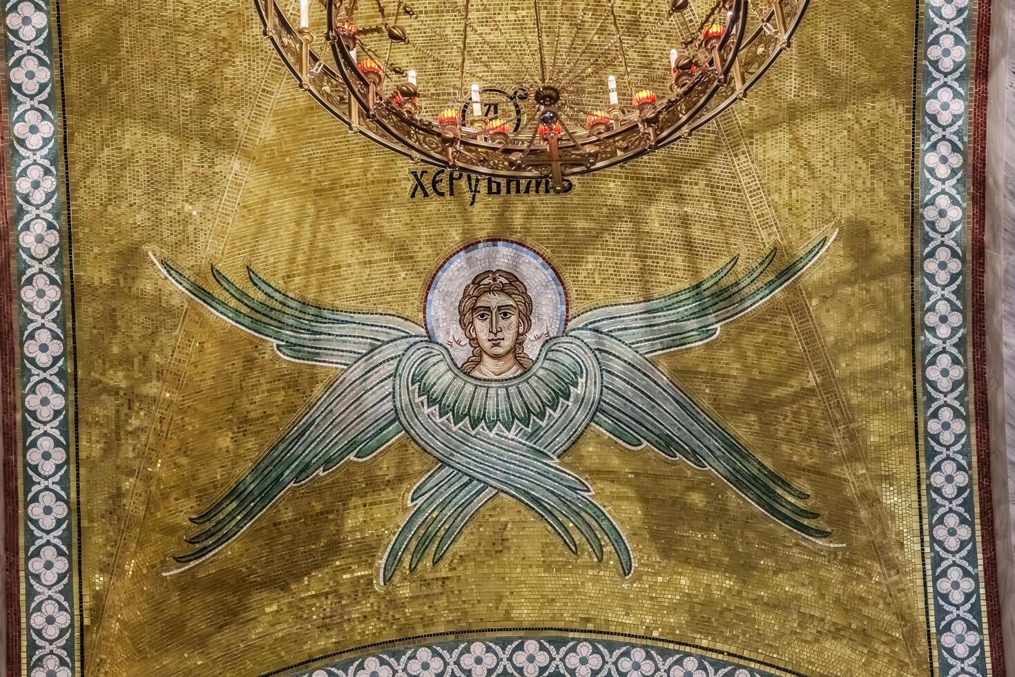 A gold and green mosaic with an angel and a cross photo