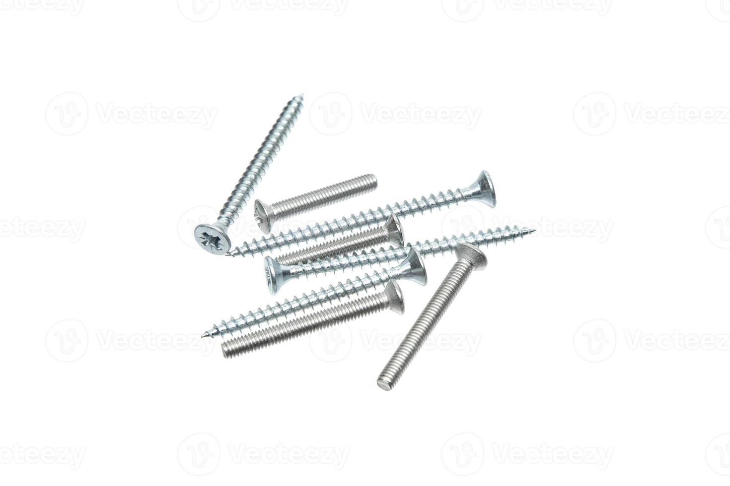 A close-up shot of silver screws scattered on a white background, highlighting various thread patterns and head designs. photo