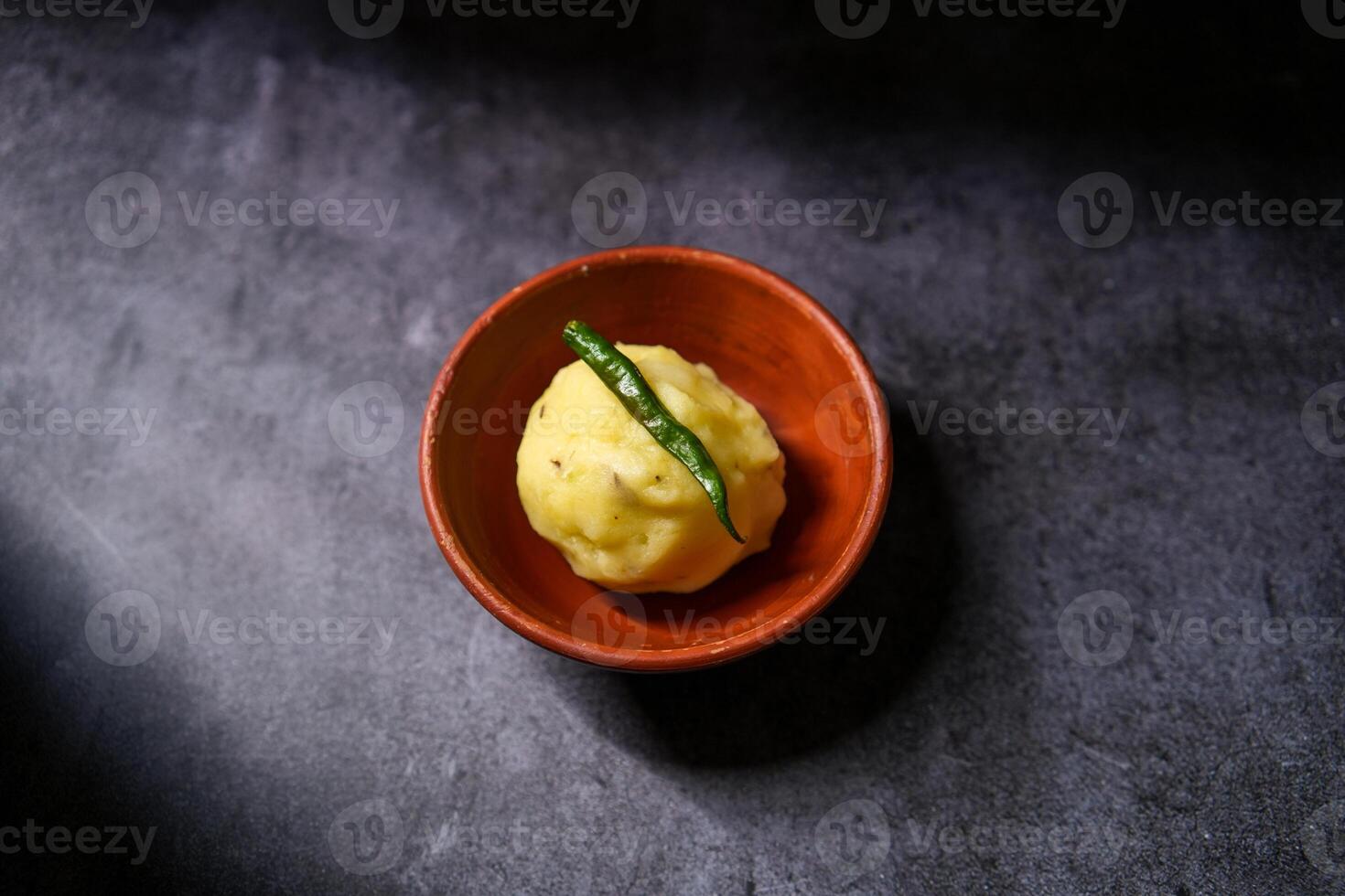 Boiled mashed potatoes are kept in a clay bowl. photo