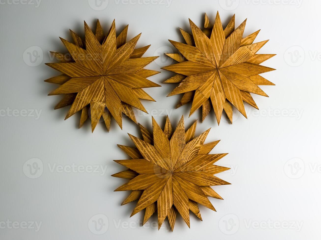 Three wooden trivets for hot dishes in the shape of snowflakes isolated on white background. Top view. photo