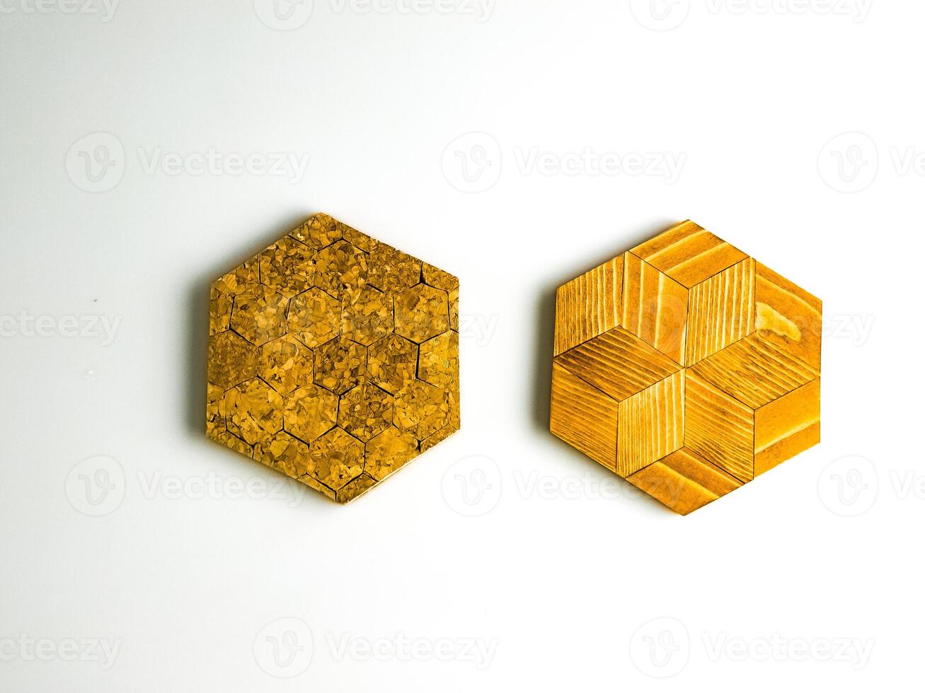 Two hexagon shaped hot plate trivets isolated on white background. One is cork, the other is wooden photo