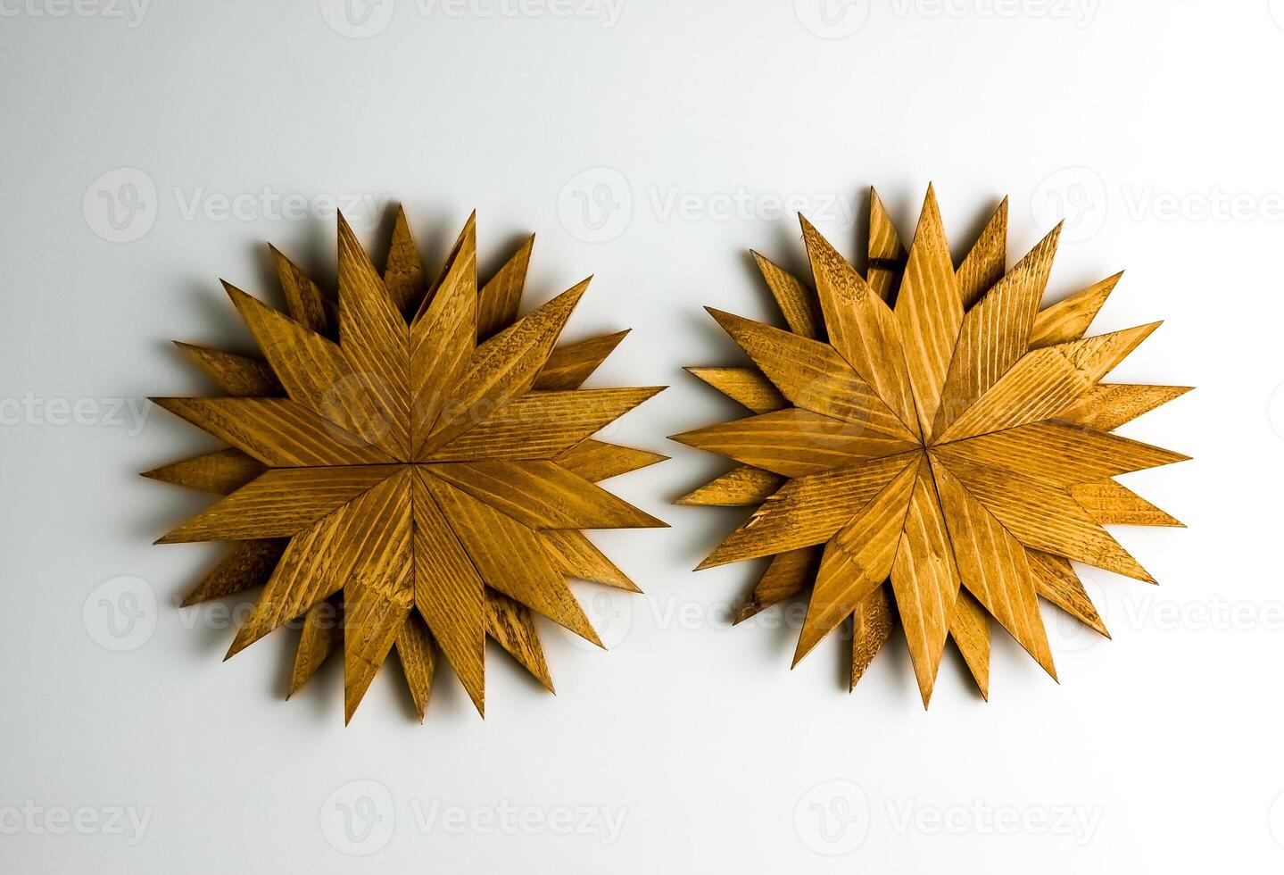Two wooden trivets for hot dishes in the shape of snowflakes isolated on white background. Top view. photo