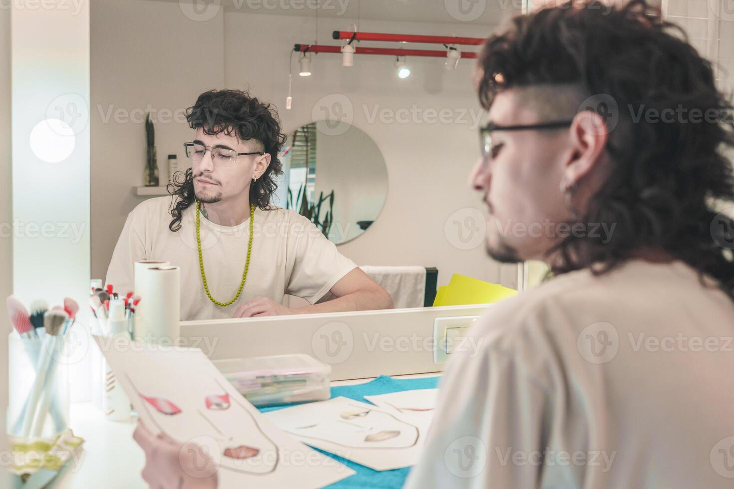 Make-up artist studying face charts in front of mirror photo
