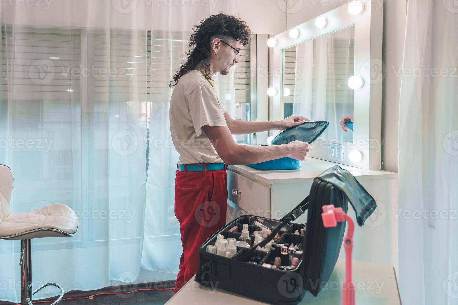 Makeup artist preparing cosmetics in dressing room with mirror and lights photo