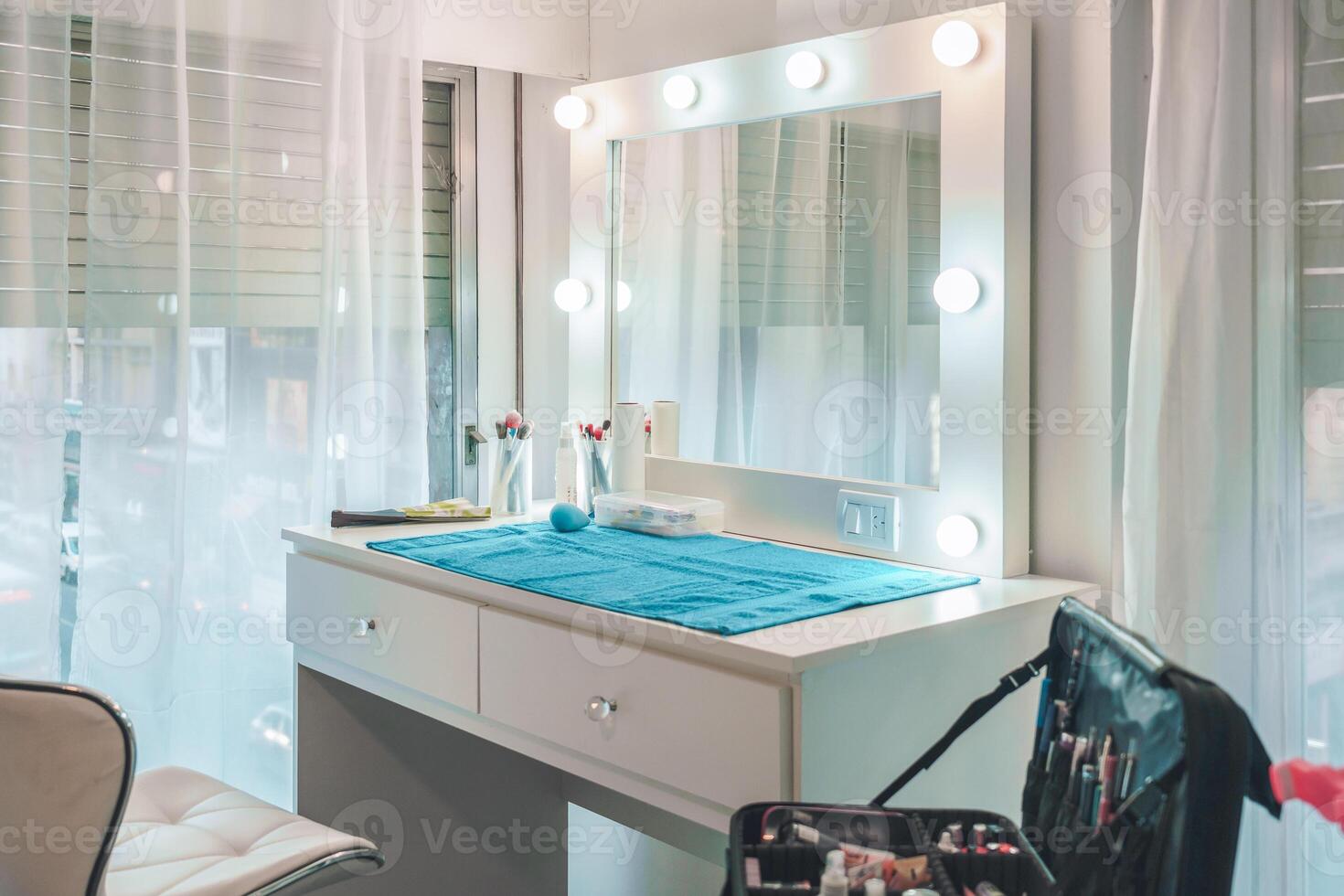 Makeup table setting with lighted mirror and beauty products displayed in a modern salon interior design photo