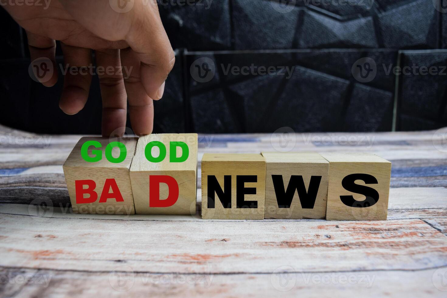 Concept word Good or bad news, hand flips cubes and changes the words bad news to good news on wooden blocks on a wooden table photo