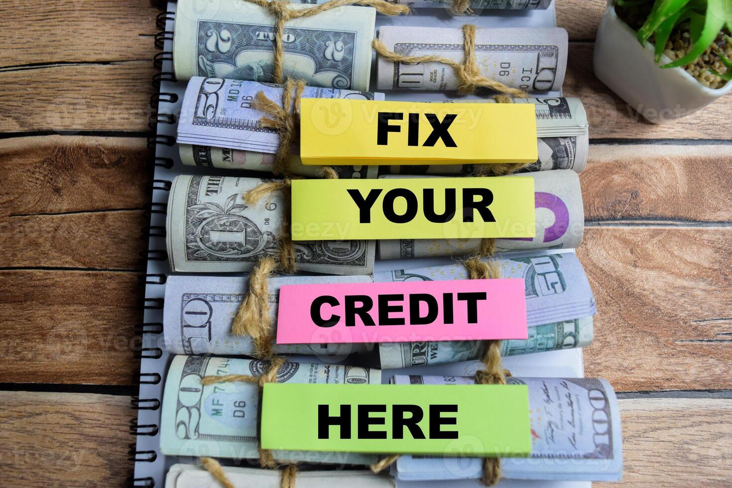 Concept of Fix Your Credit Here write on sticky notes isolated on Wooden Table. photo