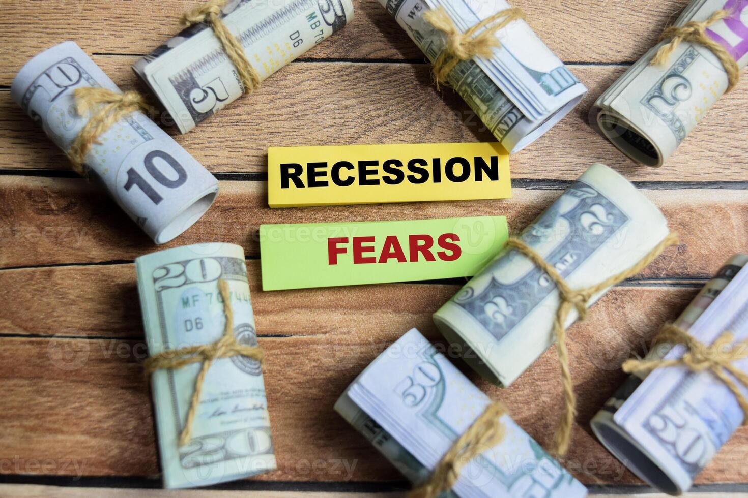 Concept Recession Fears on sticky notes on a wooden table with dollar bills photo