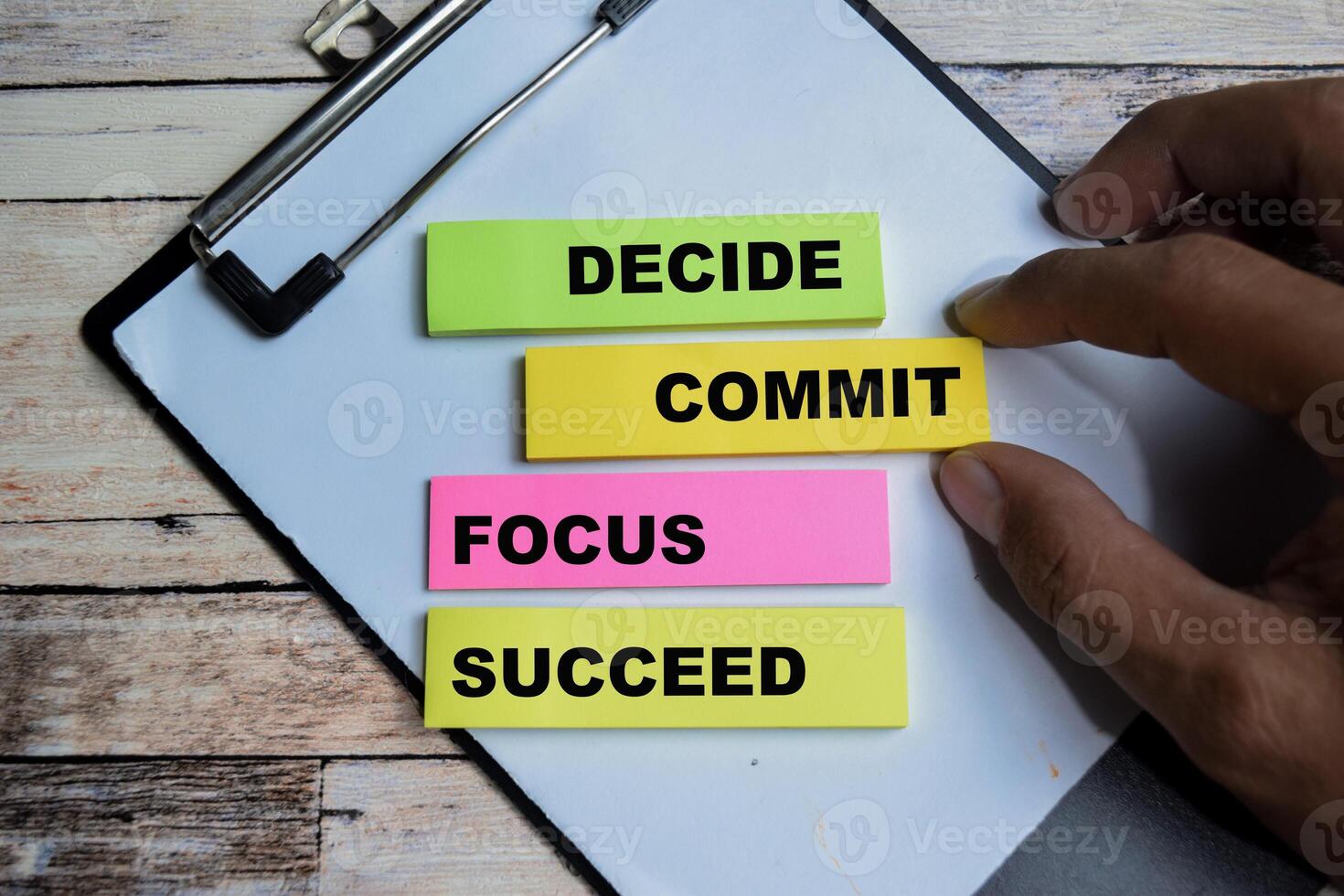 Concept of Decide Commit Focus Succeed write on sticky notes isolated on Wooden Table. photo