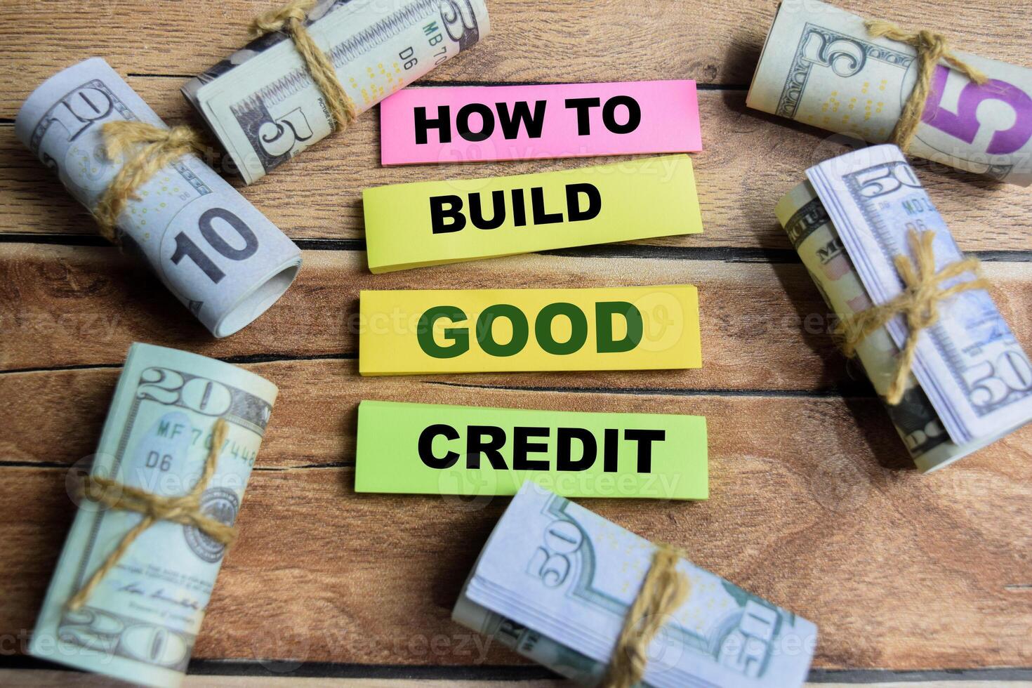 Concept word How to build good credit on wooden blocks on a wooden table with dollar bills photo