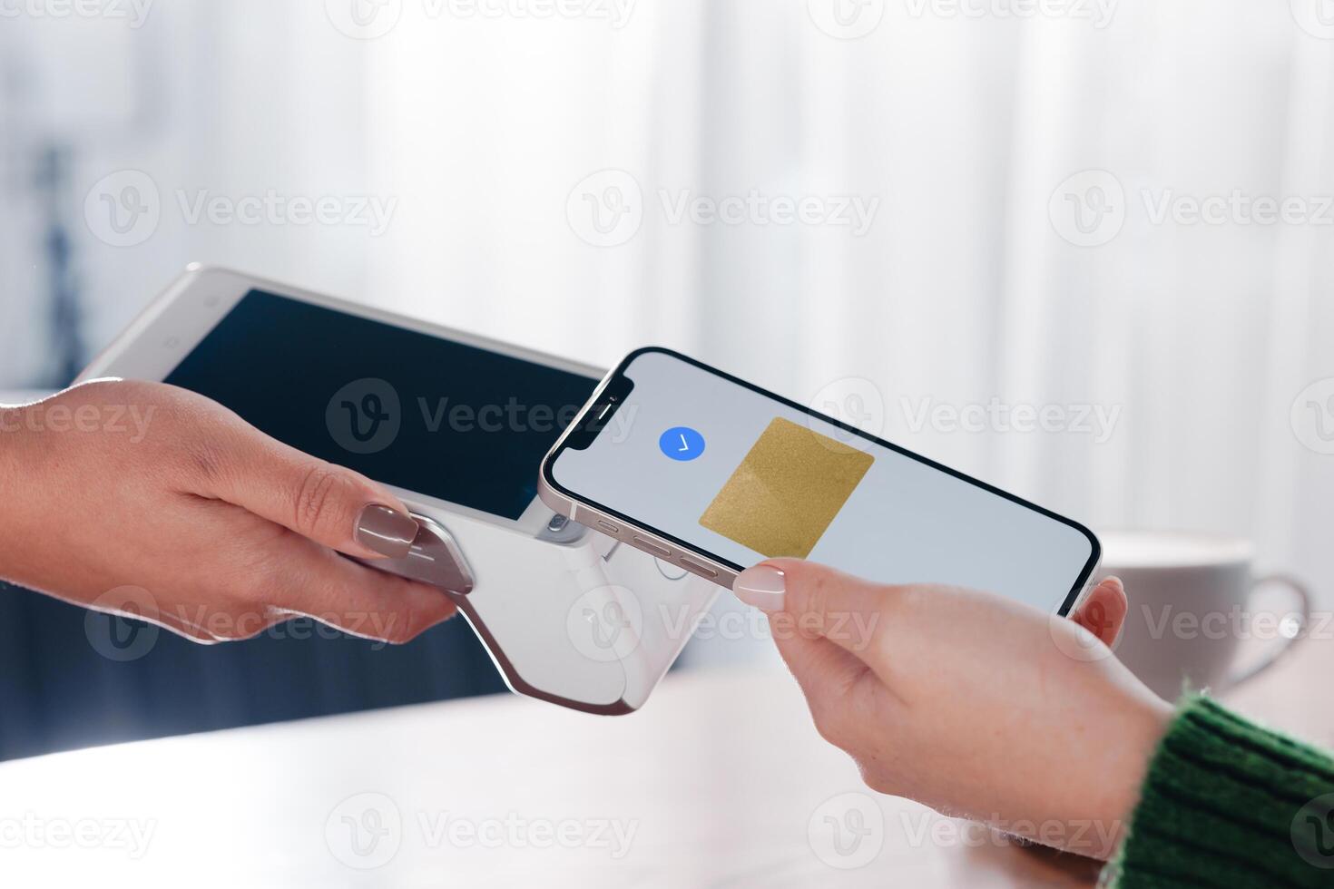 Closeup of smartphone contactless payment using NFC on terminal at cozy cafe. photo