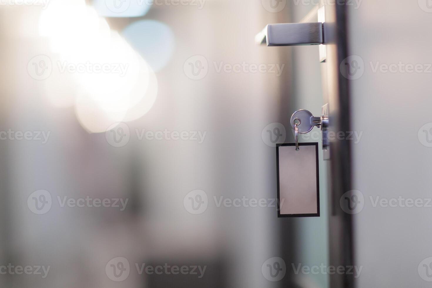 Metal key in door lock with blank tag, concept of privacy, security, or hotel access. photo