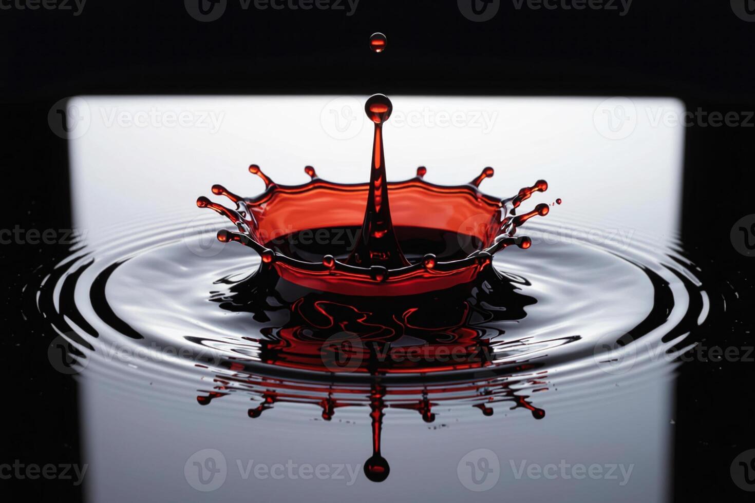 Red liquid splash and droplet over reflective black surface with ripple effect captured in macro photography with high contrast and minimal abstract style photo