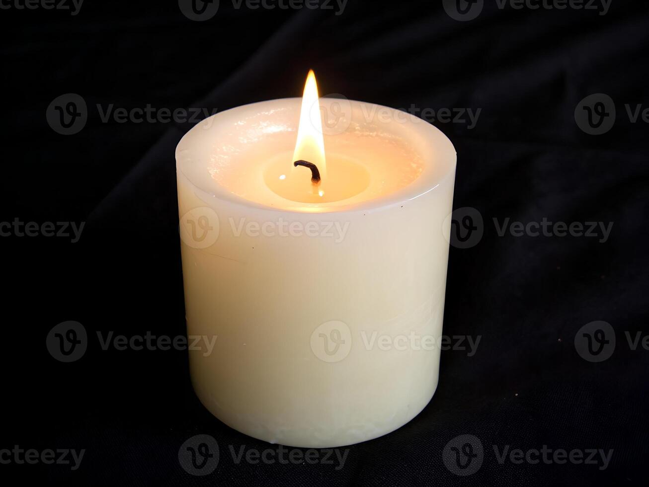 Candle with Soft Glow Isolated on Black Background. photo