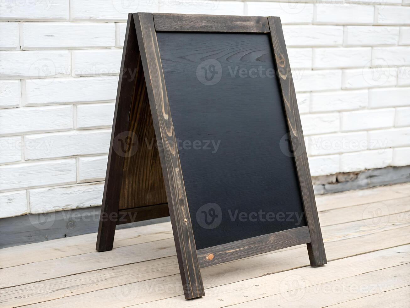A blackboard with a wooden frame sitting on a wooden floor photo