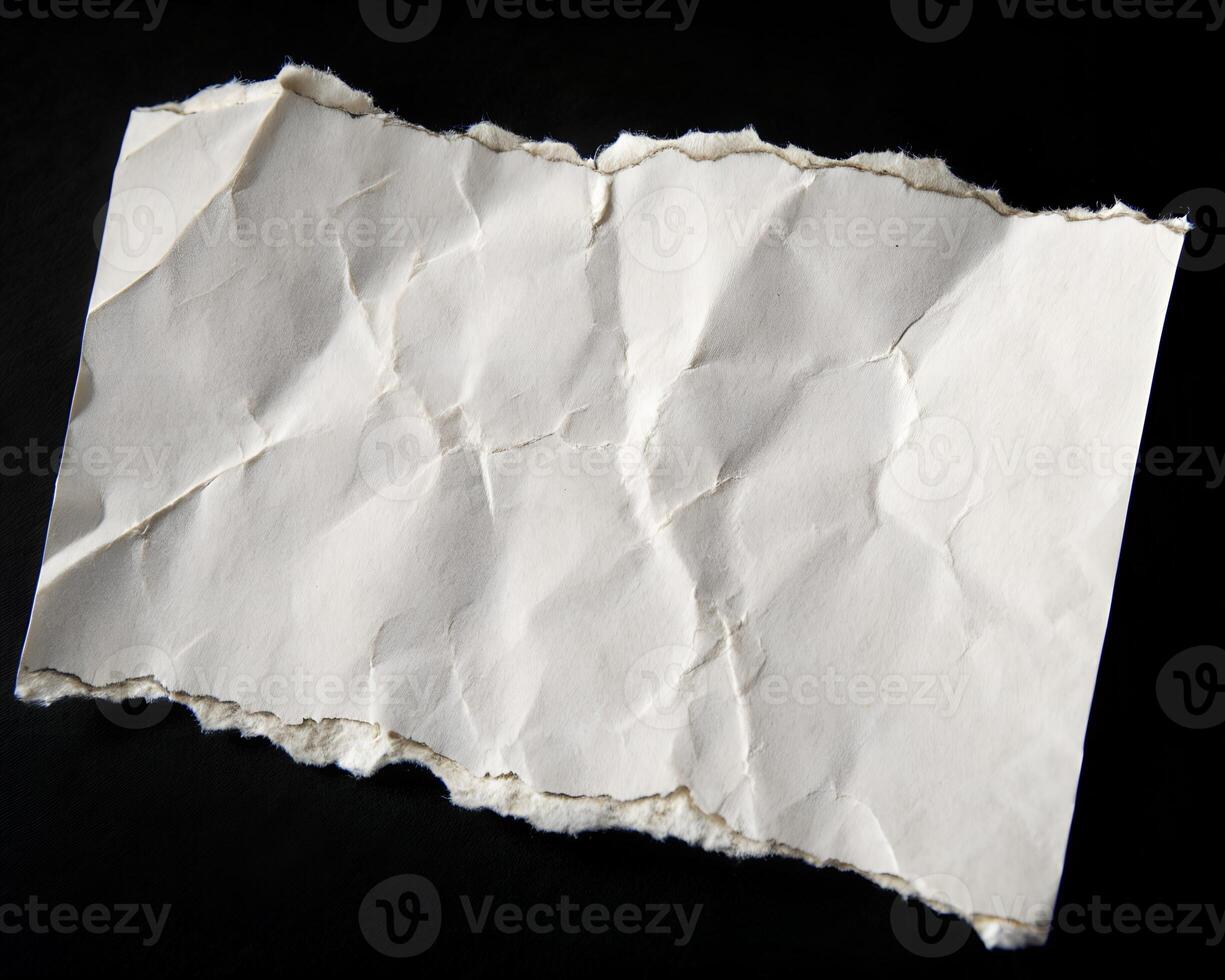 torn piece of paper isolated on black background. photo