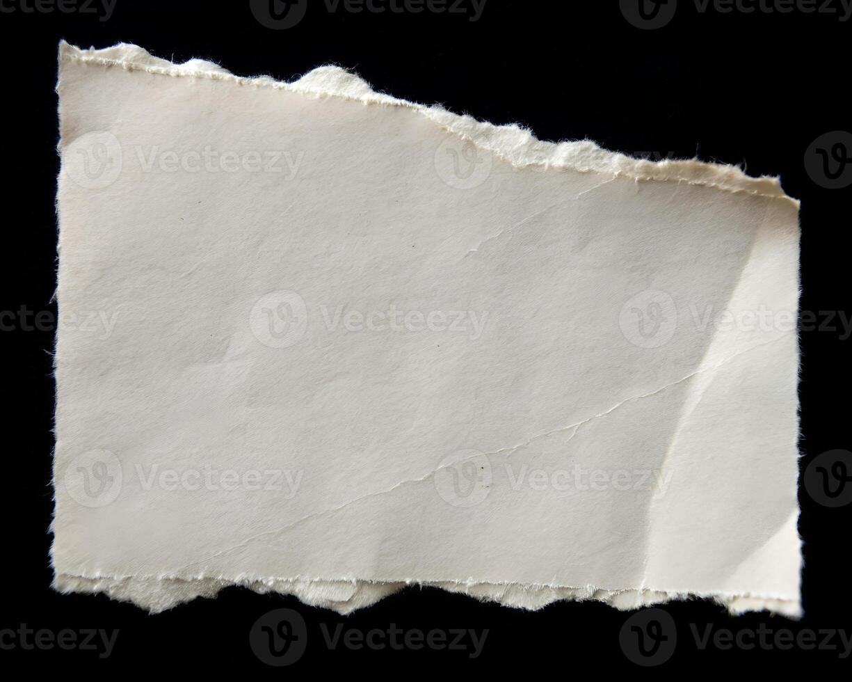torn piece of paper isolated on a black background. photo