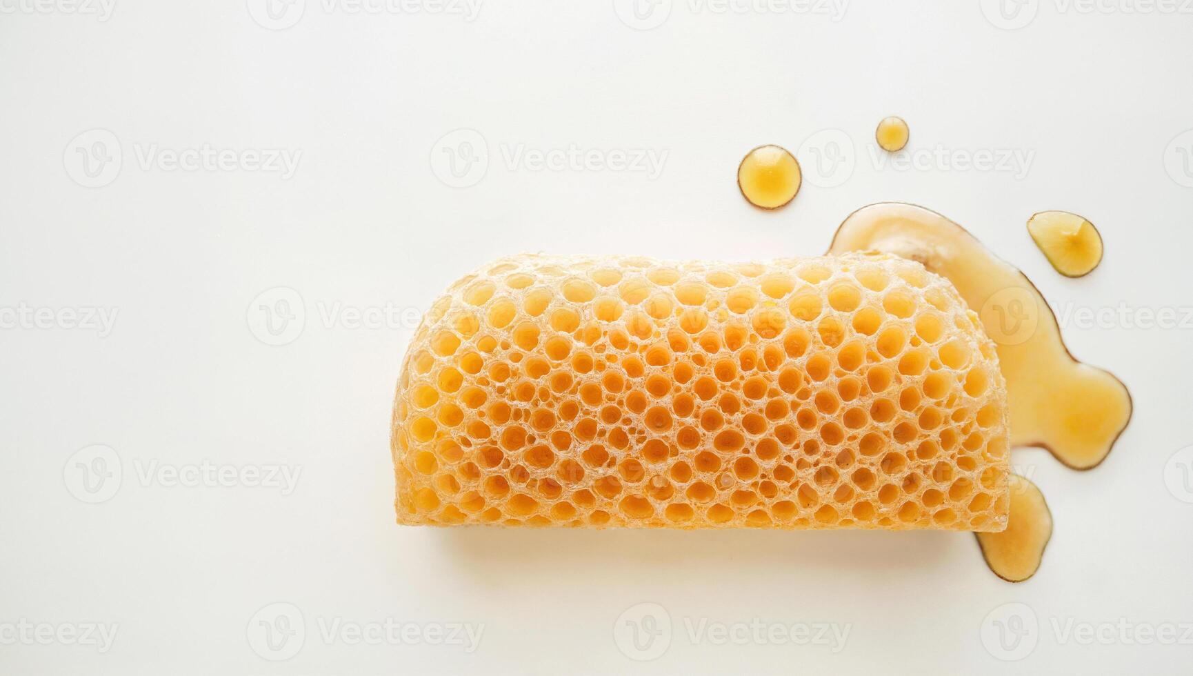 Honeycomb with Dripping Honey on White Background photo