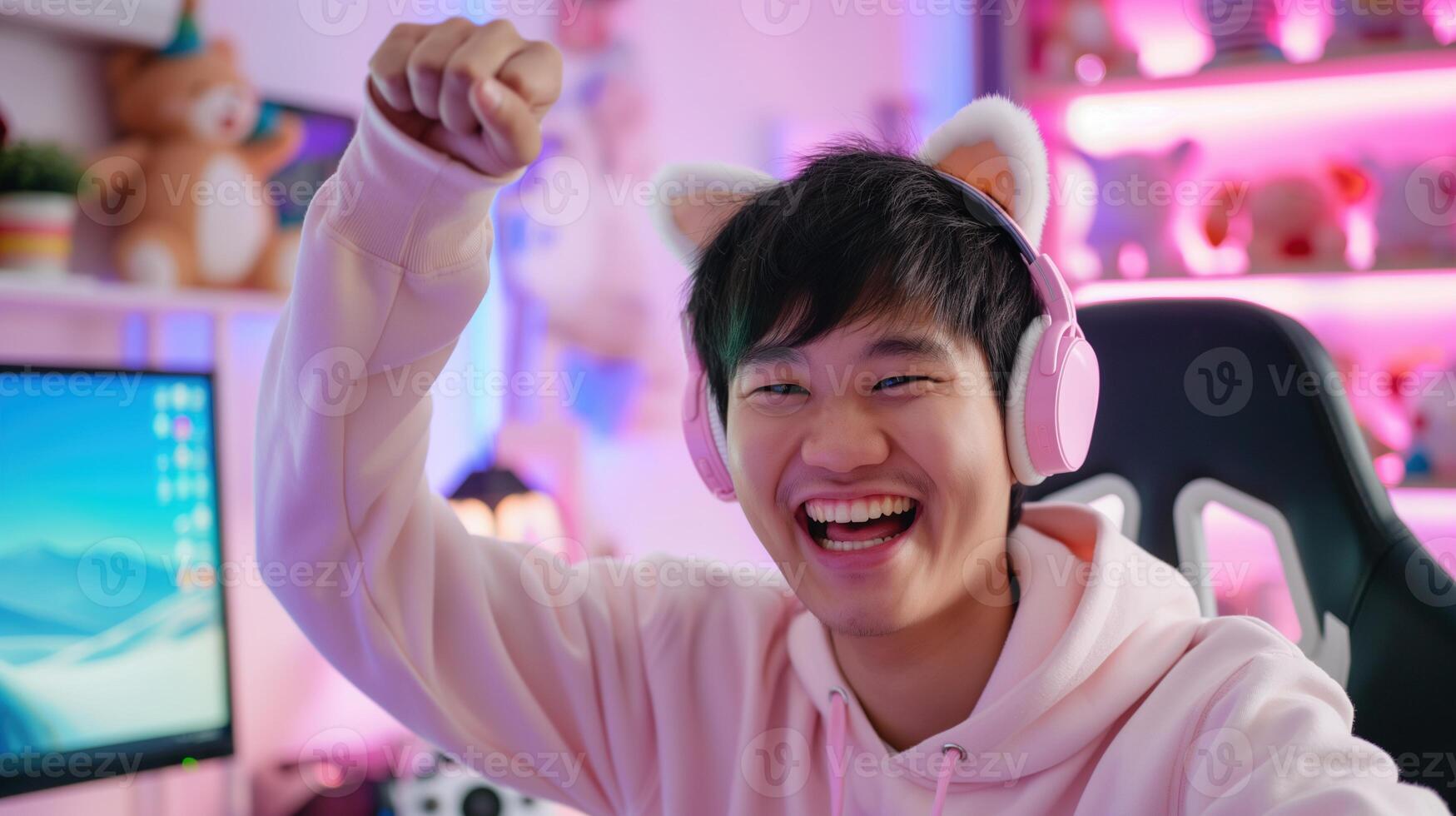 Happy asian man gamer in cat-ear headphones celebrating victory portrait image. Cute male geek nerd raising fist photography human scene. Esport content creator concept photo-realistic photo