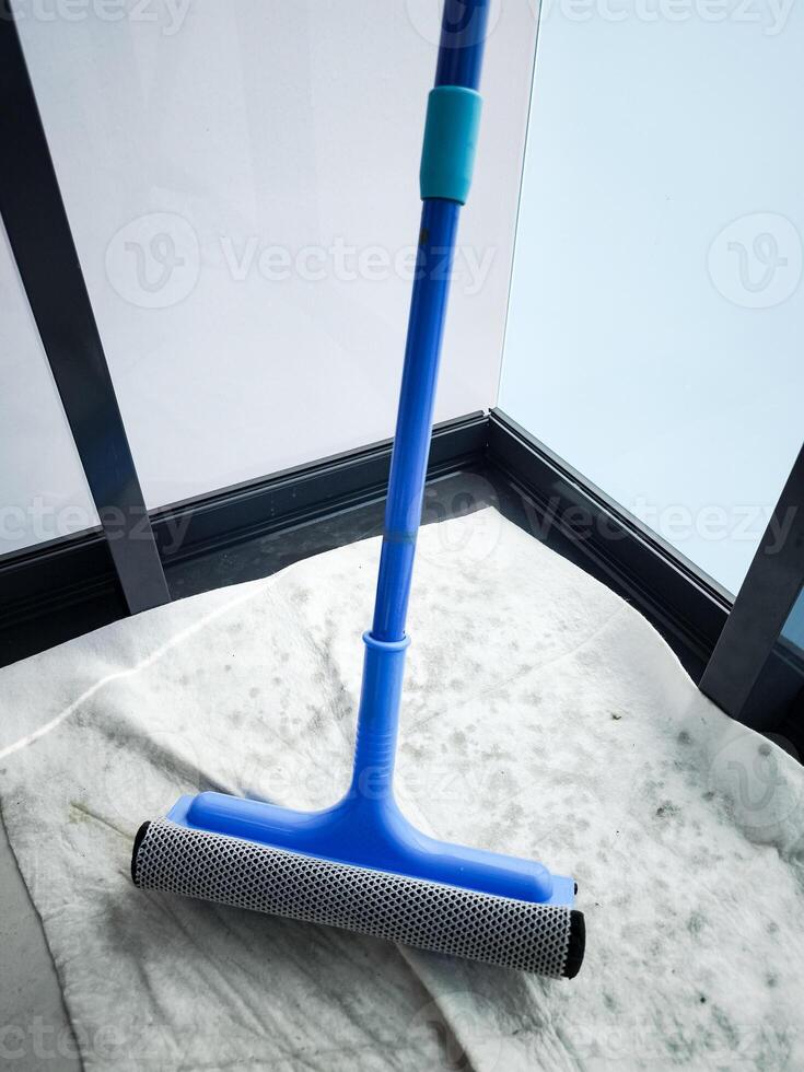 Cleaning windows with a blue squeegee during spring cleaning photo