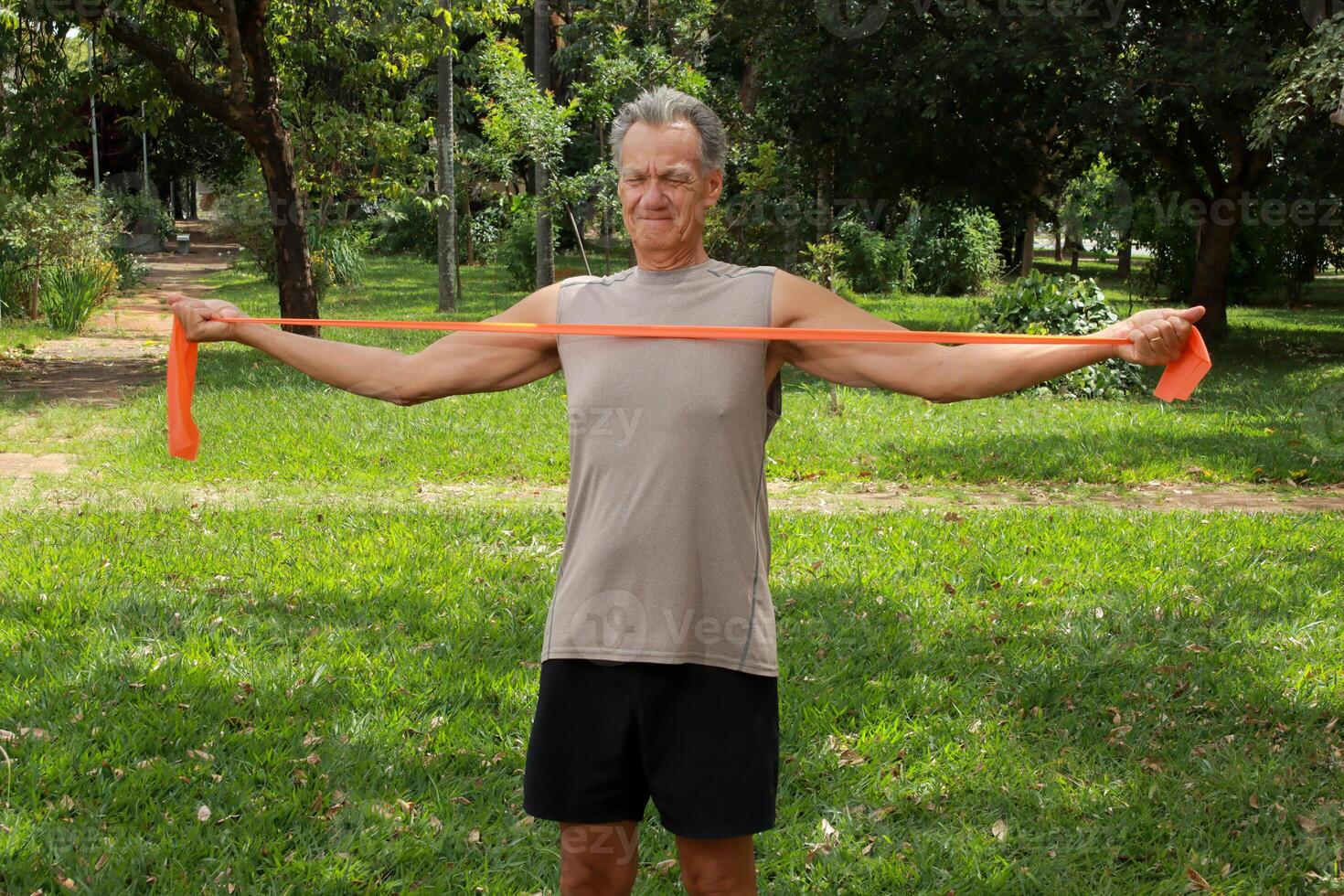 Mature Man at the Park using a fitness Rubber band or Stretch Bands for increase mobility and Strength photo
