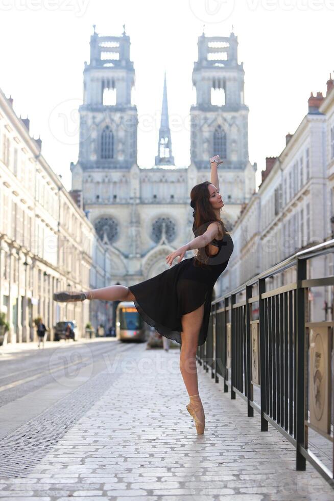 Ballerina performing arabesque near cathedral photo