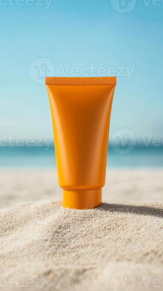 Orange tube of sunscreen sits atop soft sand at beach, with calm turquoise water lapping at shore and sunlight creating a warm ambiance on the scene photo