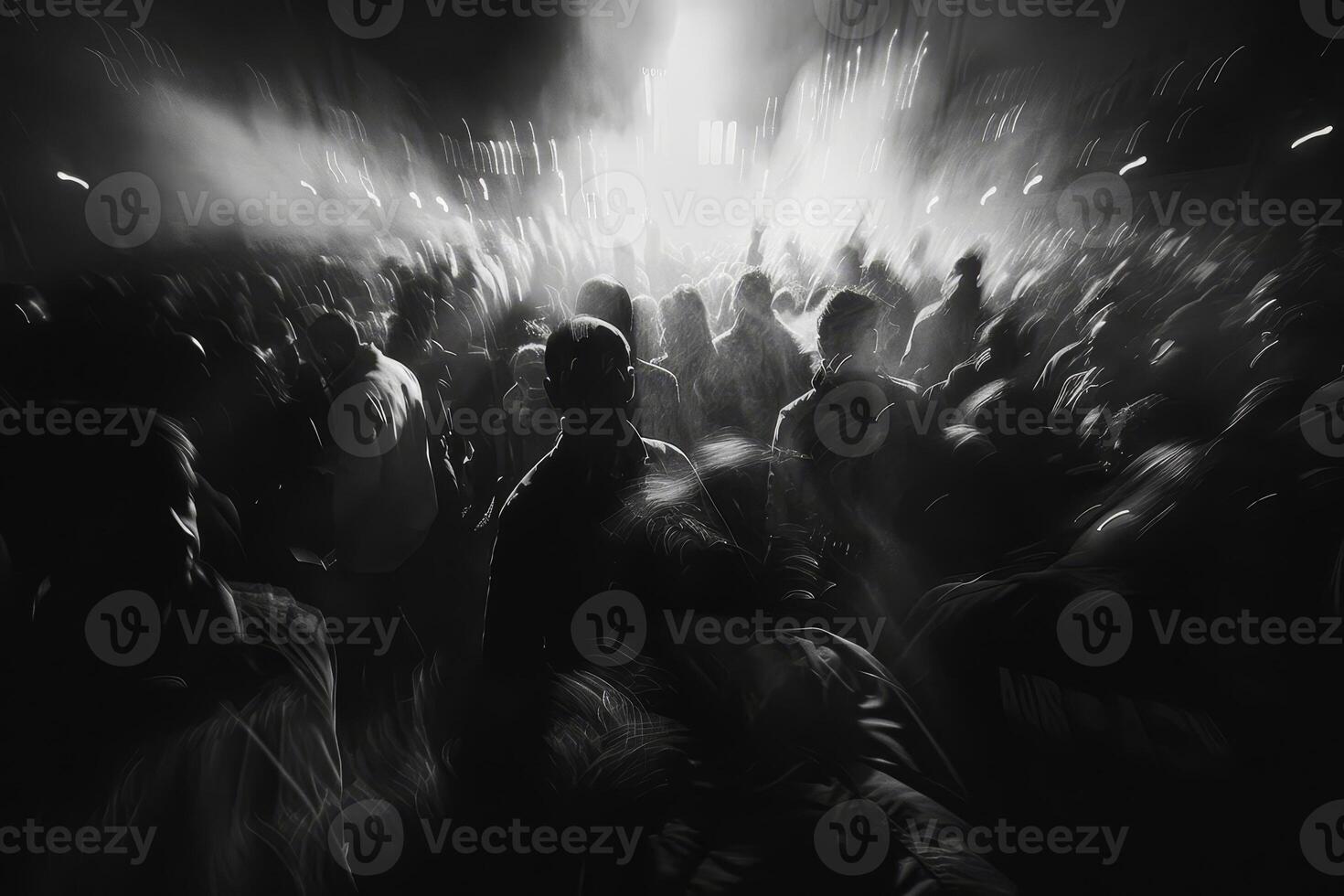 A large gathering of people in black and white fills the area, creating a lively atmosphere during a nighttime event photo