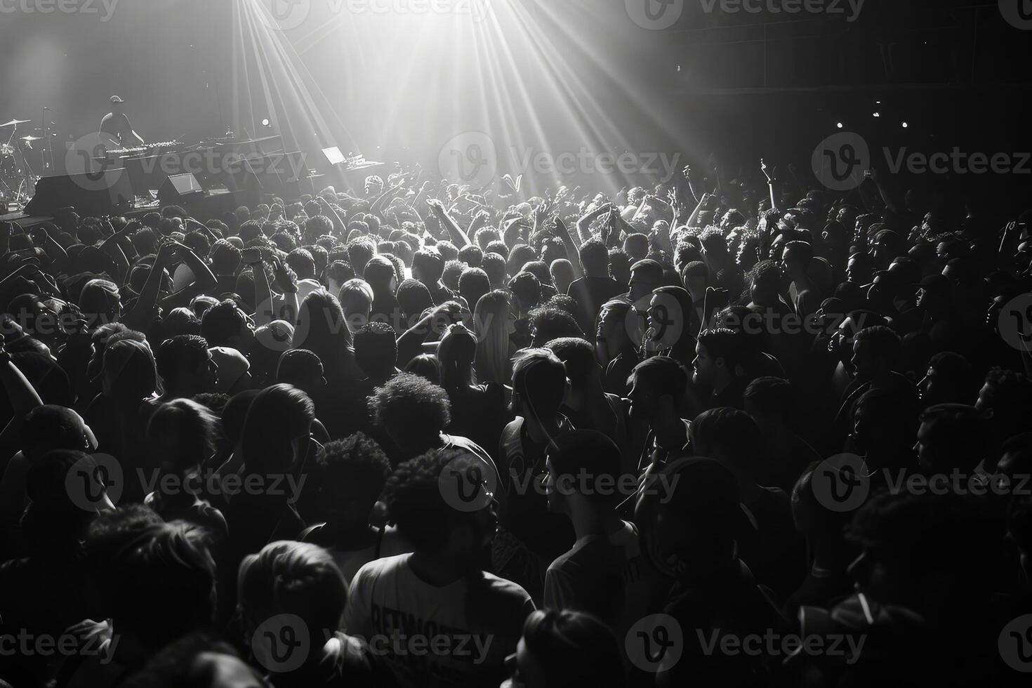A large gathering of concertgoers engage passionately at a live music event, immersed in the atmosphere created by the lighting photo
