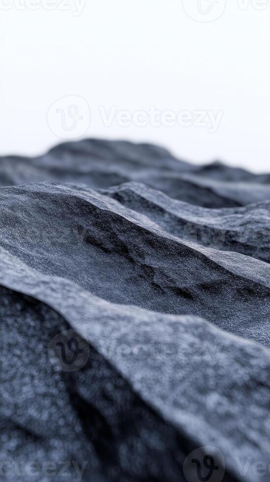 In a dramatic landscape, a black mountain range emerges with textured rock formations under dark blue lighting, creating a striking visual depth and intrigue photo