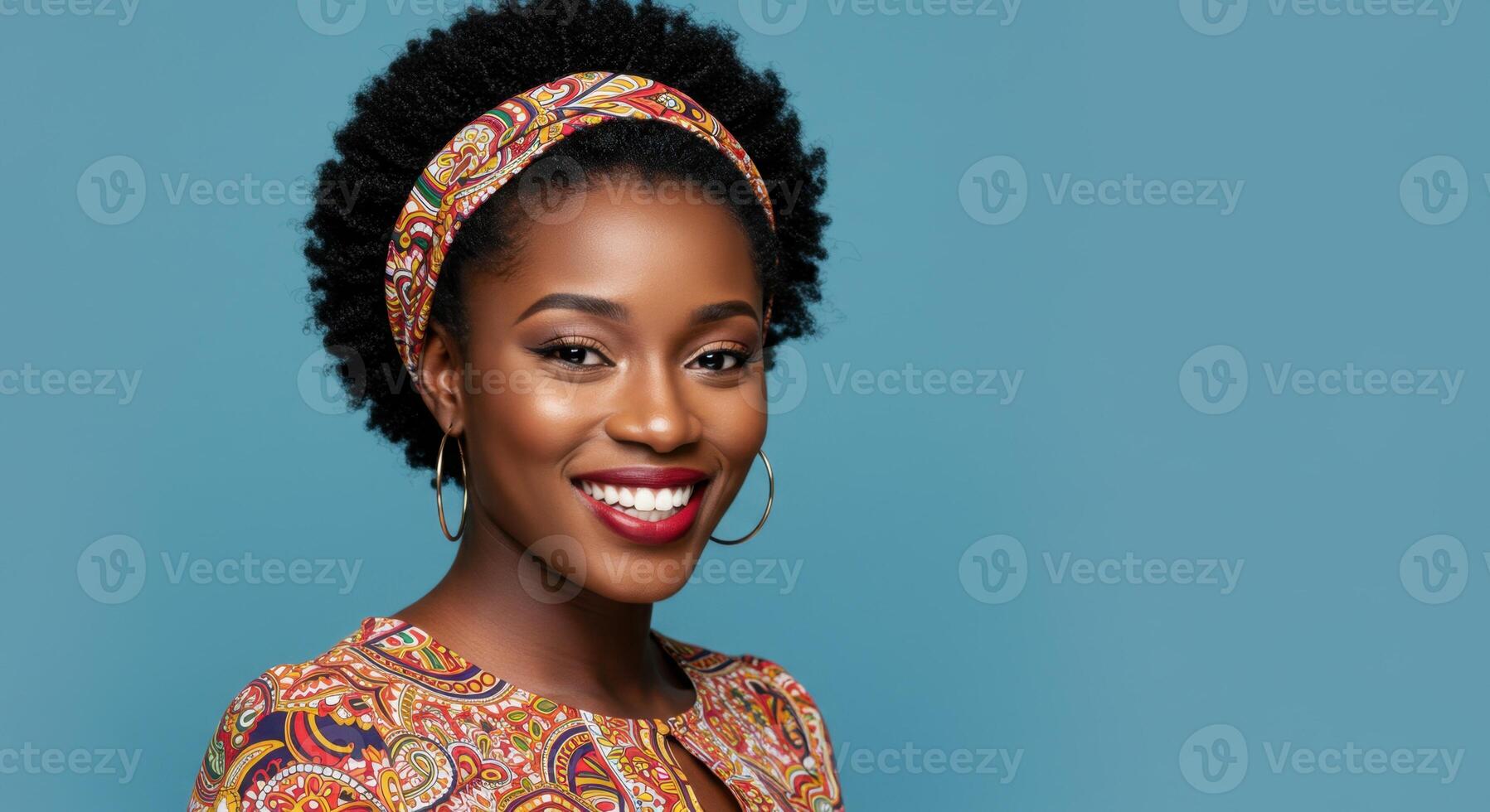 Confident African Woman Smiling in Colorful Outfit with Headband Against Blue Background photo