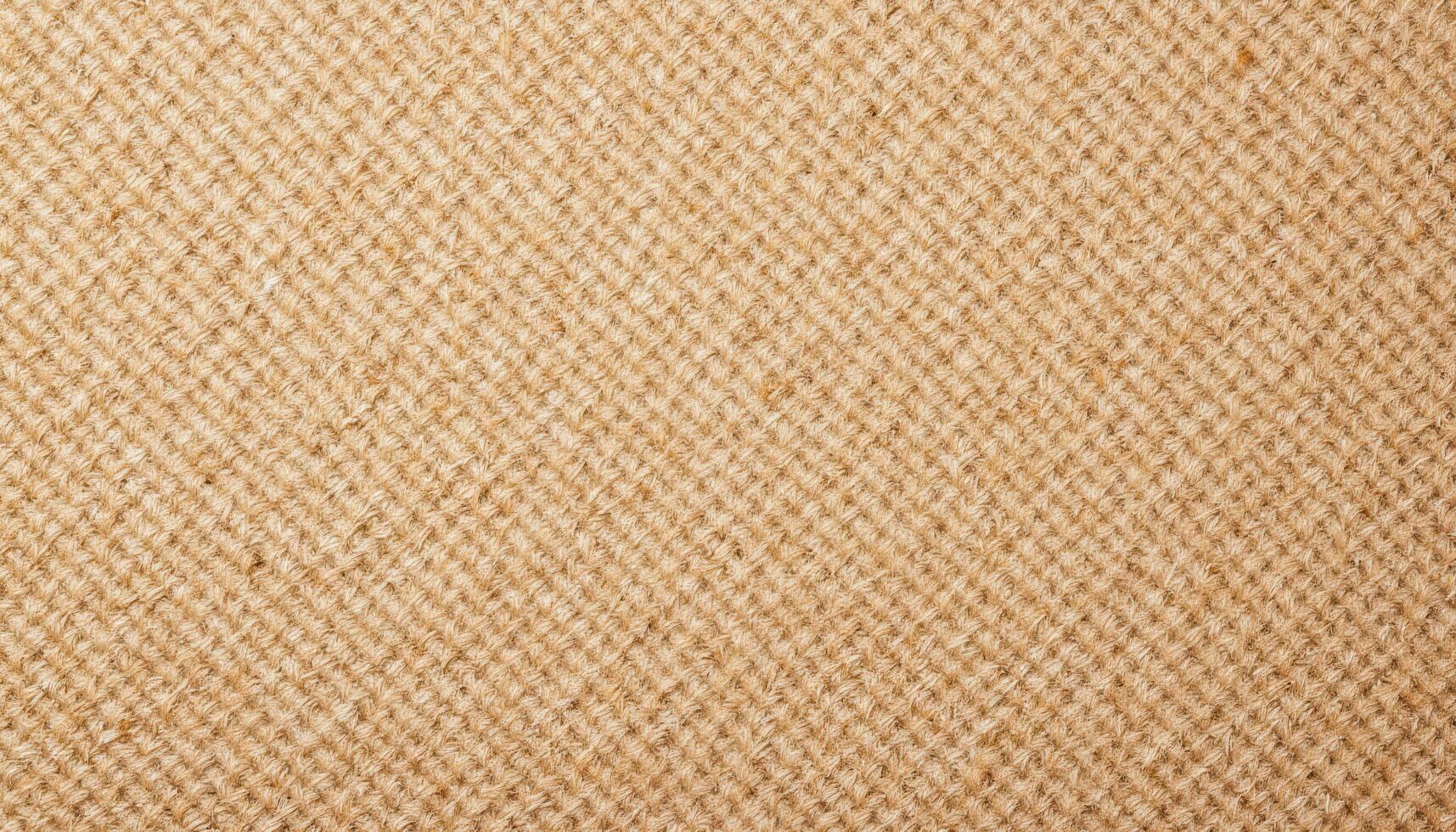 The texture of rough burlap fabric, showing the coarse weave and natural imperfections. photo