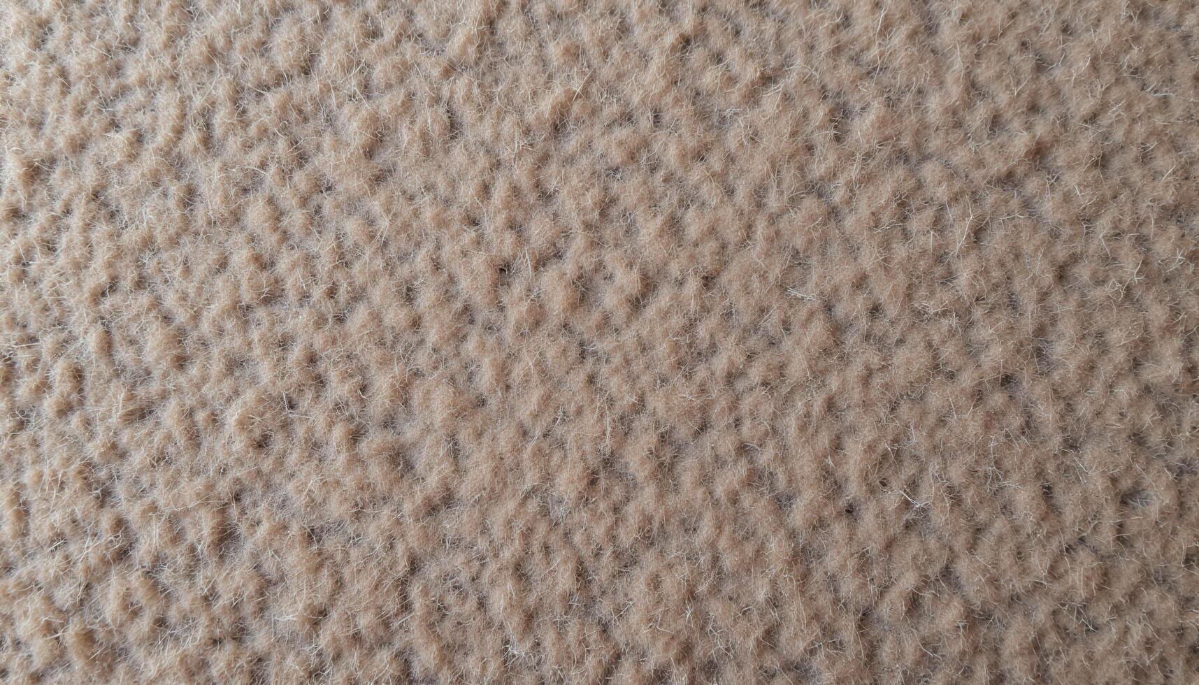 The texture of rough wool fabric, showing the weave and natural imperfections of the fibers. photo