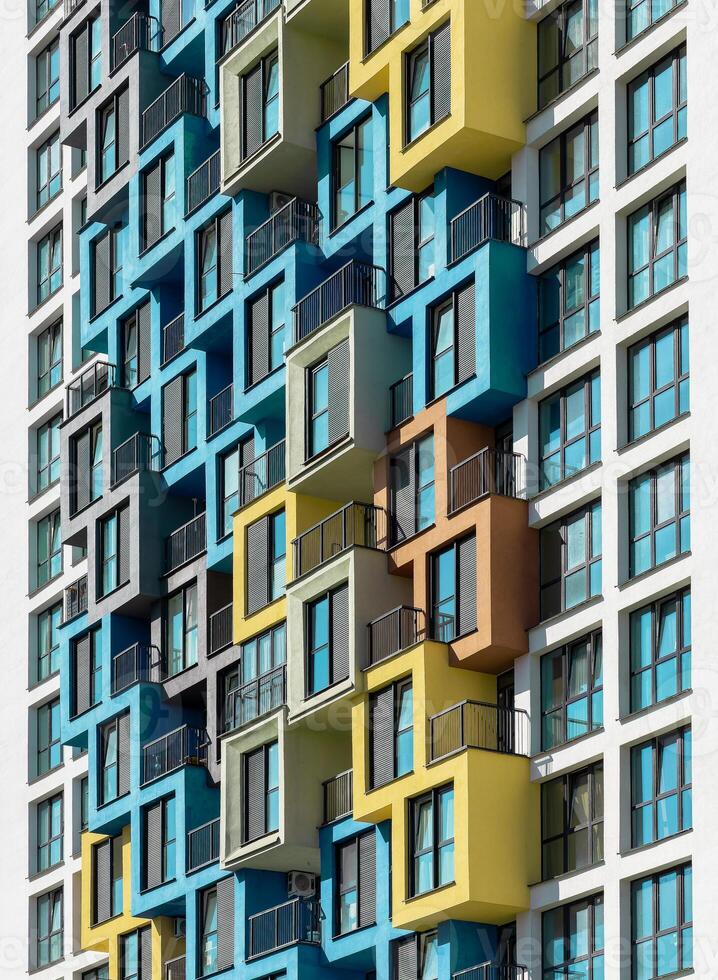 Building with colorful architecture. Tall highrise apartment with multicolored balcony pattern, photo