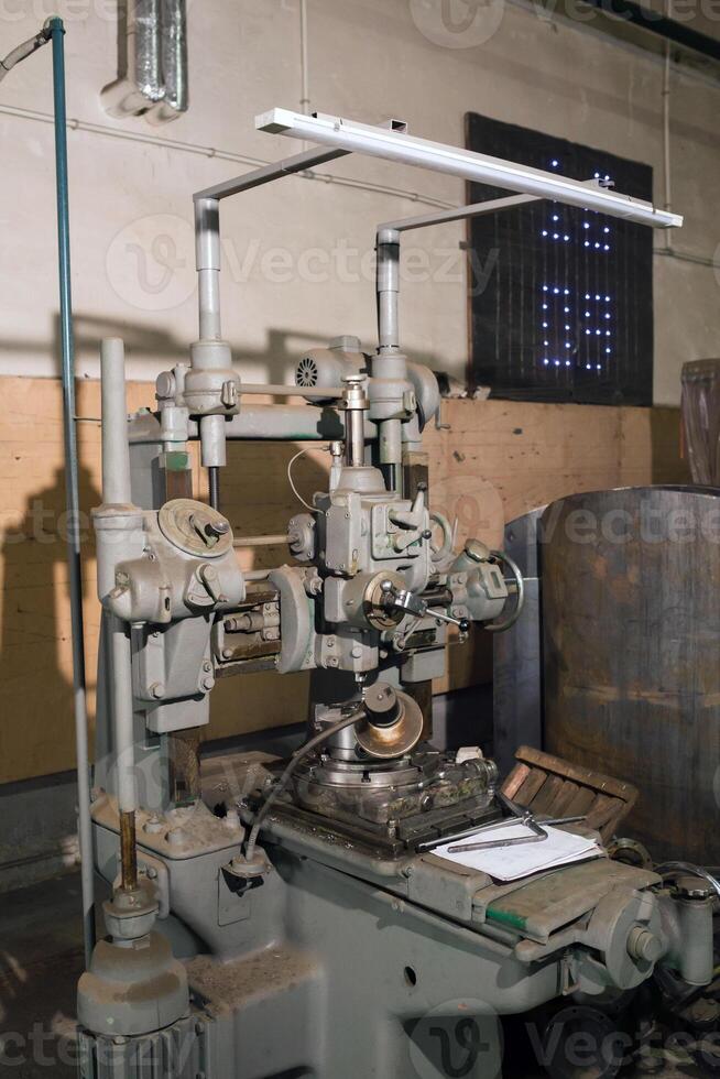 Vintage milling machine located in an industrial workshop, showcasing the intricate engineering and design from earlier manufacturing eras during daylight photo