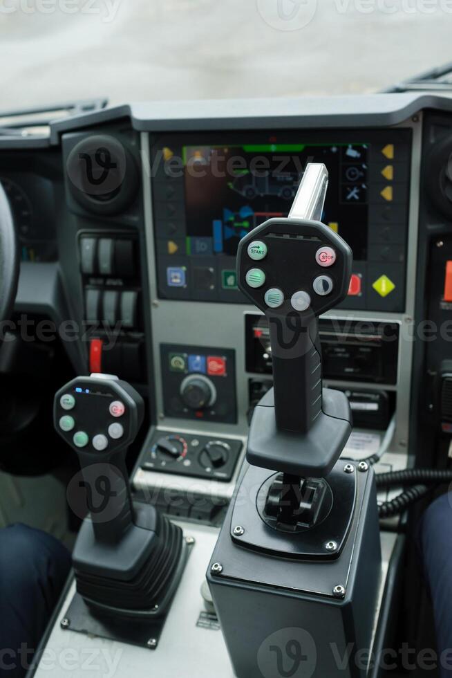 Control panel with joystick handles for operating heavy machinery in a construction site during daylight photo