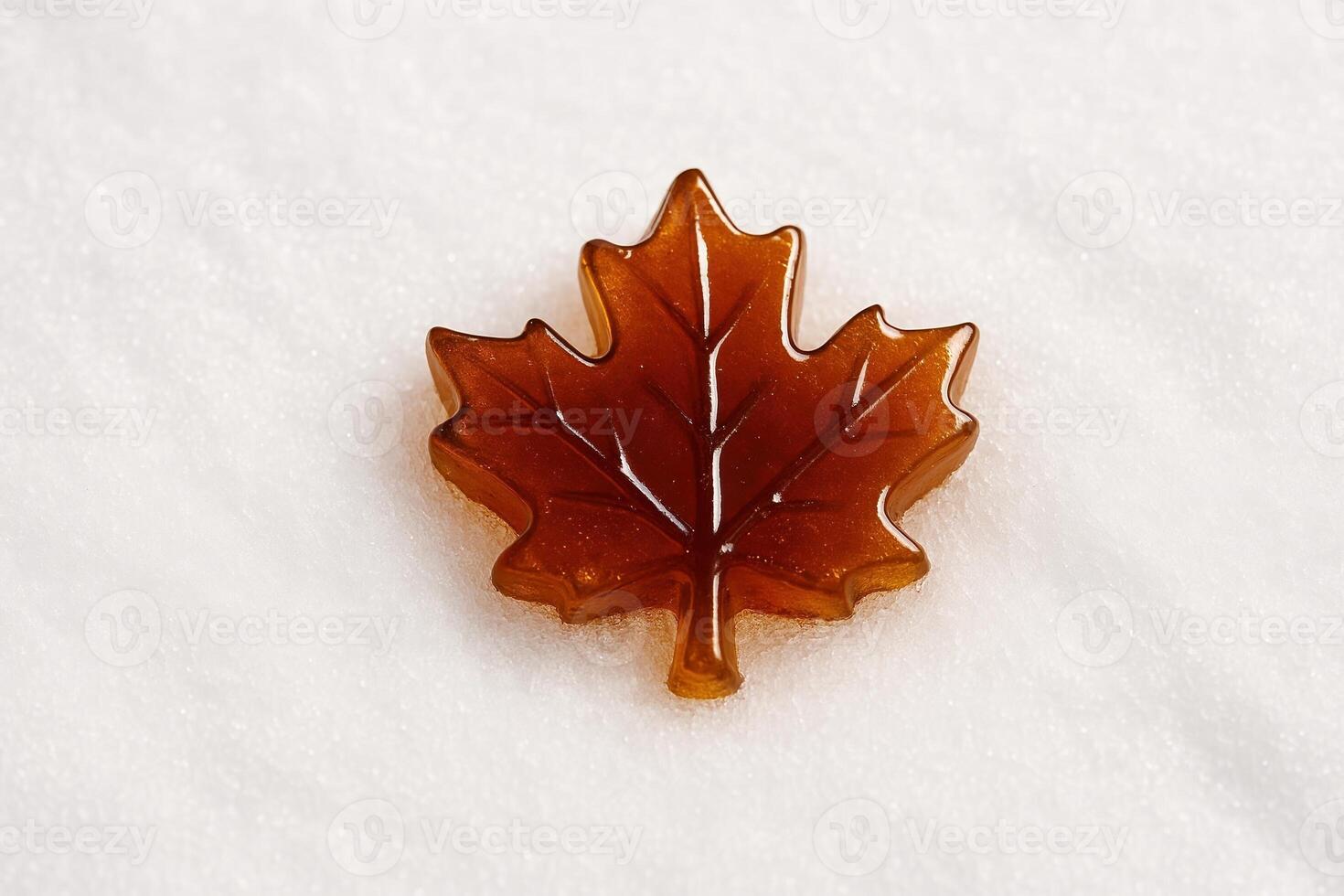 Canadian Maple Syrup Shaped as Leaf Representing Authentic Boiled Tree Sap on Snow Celebrating Traditional Spring Food Culture in Quebec and Eastern Canada Sugar Shack photo